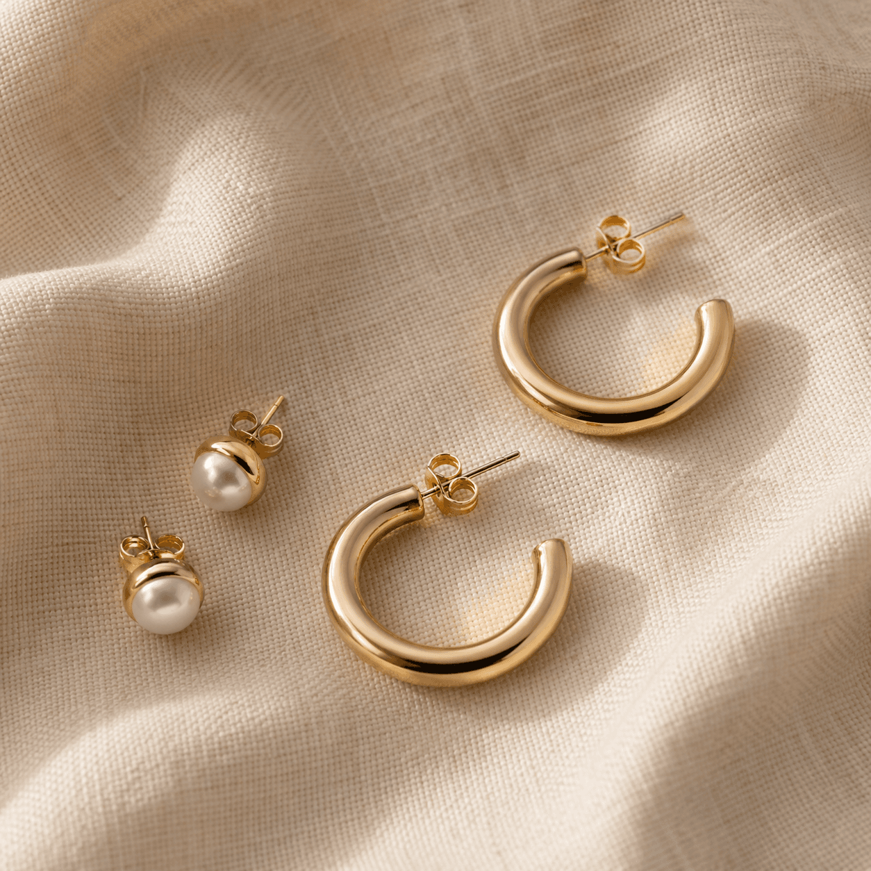 Empty-cart category pick: pearl studs and small hoops on warm linen.